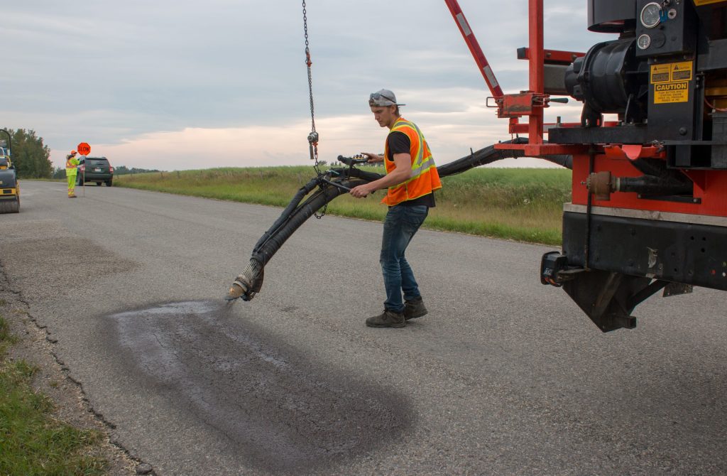 asphalt product being applied by spray patcher in alberta